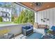 Relaxing covered patio with comfortable seating, wood ceiling and fan, overlooking lush greenery at 212 Sessions St, Woodstock, GA 30188