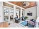 Inviting covered patio featuring wood ceiling, ceiling fan, comfortable seating, and decor at 212 Sessions St, Woodstock, GA 30188