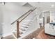 Wooden staircase with white risers leading to a second floor and views of the kitchen at 212 Sessions St, Woodstock, GA 30188