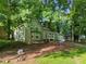 Quaint home nestled among mature trees boasts a charming exterior and landscaped front yard at 5248 Martins Crossing Rd, Stone Mountain, GA 30088