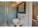 Bathroom features a pedestal sink, decorative mirror, and glass shower with chrome hardware at 5327 David Cir, Covington, GA 30014