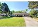 Charming one-story brick home featuring lush green lawn, manicured shrubs, and a long driveway at 5327 David Cir, Covington, GA 30014