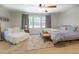 Bright main bedroom includes a seating area, ceiling fan, and large windows for natural light at 5327 David Cir, Covington, GA 30014
