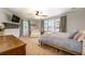 Spacious main bedroom boasts a ceiling fan, large windows, and a cozy sitting area with a white loveseat at 5327 David Cir, Covington, GA 30014