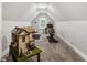 Finished attic space with carpeting, exercise bike, and charming miniature house on a table at 5850 Overlook Rdg, Suwanee, GA 30024