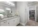 Light filled bathroom featuring double sinks, granite counters, tile floors, and walk-in closet at 5850 Overlook Rdg, Suwanee, GA 30024