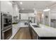 Bright kitchen with white cabinets, granite countertops, stainless appliances, and center island with bar seating at 5850 Overlook Rdg, Suwanee, GA 30024