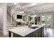 Open-concept kitchen flowing into the living area, featuring an island with seating and modern finishes at 5850 Overlook Rdg, Suwanee, GA 30024
