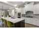 Modern kitchen featuring a large island with seating, white cabinetry, and stainless steel appliances at 5850 Overlook Rdg, Suwanee, GA 30024