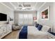 Bright main bedroom featuring crown moulding, tray ceiling, hardwood floors, and a comfortable sitting area at 5850 Overlook Rdg, Suwanee, GA 30024