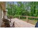 Back deck featuring wood flooring, outdoor furniture, wooden railing, and surrounded by lush green foliage at 685 Maplelake Dr, Acworth, GA 30101