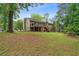 Back exterior showcasing a raised deck, fenced-in yard, grassy area, and charming two-story home at 685 Maplelake Dr, Acworth, GA 30101