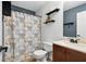 Bathroom featuring a shower with patterned curtain, matching sink and vanity, dark fixtures, and decorative shelves at 685 Maplelake Dr, Acworth, GA 30101