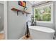 Elegant bathroom with a modern soaking tub and a large window overlooking the greenery at 685 Maplelake Dr, Acworth, GA 30101