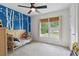 Bedroom showcasing unique tree-themed accent wall, light colored carpet, single bed, and bright window with shades at 685 Maplelake Dr, Acworth, GA 30101