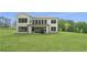 Large backyard with a patio, lush green grass, and a two-story white home at 17145 River Overlook Dr, Roswell, GA 30075