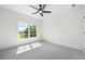 Comfortable bedroom with carpeted floors, a ceiling fan, and a large window with scenic outside views at 17145 River Overlook Dr, Roswell, GA 30075