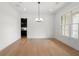 Light filled dining room with hardwood floors, chandelier and a bar area at 17145 River Overlook Dr, Roswell, GA 30075