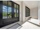 Close-up of the front door and entry featuring large black framed windows, a brick base, and a welcome mat at 17145 River Overlook Dr, Roswell, GA 30075