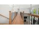 Bright hallway with hardwood floors, black metal railings, and natural light from nearby windows at 17145 River Overlook Dr, Roswell, GA 30075