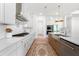 Modern kitchen boasts stainless steel appliances, white cabinets, stone countertops, hardwood floors, and a gas stovetop at 17145 River Overlook Dr, Roswell, GA 30075
