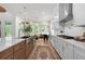 Modern kitchen with white cabinets, stainless steel appliances, and a view of the bright sunroom at 17145 River Overlook Dr, Roswell, GA 30075