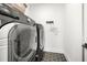 Modern laundry room with front loading washer and dryer set on stylish hexagon tile floor at 17145 River Overlook Dr, Roswell, GA 30075