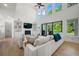 Bright living room boasts soaring ceilings, large windows, built-in shelving, fireplace, and hardwood floors at 17145 River Overlook Dr, Roswell, GA 30075
