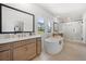 Luxurious bathroom featuring dual sinks, a soaking tub, and a frameless glass shower at 17145 River Overlook Dr, Roswell, GA 30075
