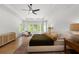 Bright main bedroom featuring neutral colors, large windows, ceiling fan, and hardwood floors at 17145 River Overlook Dr, Roswell, GA 30075