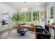 Bright sunroom with large windows, comfortable seating, and views of the backyard at 17145 River Overlook Dr, Roswell, GA 30075