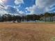 Community tennis courts surrounded by chain link fence and mature trees at 1745 Collines Sw Ave, Atlanta, GA 30331