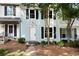 Charming townhouse featuring a light blue exterior, black shutters, and well-maintained landscaping at 1807 Queen Anne Ct, Sandy Springs, GA 30350