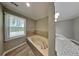 Bright bathroom features a soaking tub by the window and double granite vanity at 2068 Signal Ridge Nw, Kennesaw, GA 30152