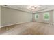 Spacious bedroom with plush carpeting, two large windows, and a modern ceiling fan at 2068 Signal Ridge Nw, Kennesaw, GA 30152