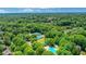 A panoramic view of a community, showcasing lush green surroundings, tennis courts, pool, and homes at 6030 Sweet Creek Rd, Duluth, GA 30097