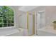 This bathroom features an arched window, a shower with a tub and a sink with white cabinets at 6030 Sweet Creek Rd, Duluth, GA 30097