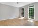 This bedroom has hardwood floors, two windows and a ceiling fan at 6030 Sweet Creek Rd, Duluth, GA 30097