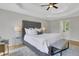 This bedroom features a tufted headboard and a tray ceiling with a ceiling fan at 6030 Sweet Creek Rd, Duluth, GA 30097