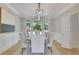 Formal dining room with wainscoting, a contemporary light fixture, and a large window with a view of the outdoors at 6030 Sweet Creek Rd, Duluth, GA 30097