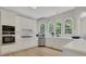 Kitchen boasting white cabinets, stainless appliances, hardwood floors, and arched windows overlooking the yard at 6030 Sweet Creek Rd, Duluth, GA 30097