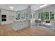 Open concept kitchen with white cabinets, hardwood floors, skylights, and dining area with backyard views at 6030 Sweet Creek Rd, Duluth, GA 30097