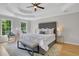 Serene main bedroom features a tray ceiling, hardwood floors, a plush bed, and abundant natural light at 6030 Sweet Creek Rd, Duluth, GA 30097