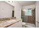 Bathroom featuring granite countertop, undermount sink, and a shower with decorative tile at 8169 Kendrick Rd, Jonesboro, GA 30238