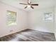 Cozy bedroom with two windows, neutral walls, ceiling fan and modern wood-look flooring at 8169 Kendrick Rd, Jonesboro, GA 30238