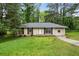 Charming single-story home with black shutters and well-maintained front yard and mature trees at 8169 Kendrick Rd, Jonesboro, GA 30238