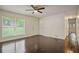 Bright living room featuring wood floors, a ceiling fan, and a large window offering natural light at 8169 Kendrick Rd, Jonesboro, GA 30238