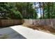 This fenced backyard features a patio and mature trees at 301 Silver Spring St, Dallas, GA 30157