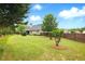 Expansive green backyard featuring a well-manicured lawn, mature trees, and a classic home exterior at 3174 Piney Woods Cir, Buford, GA 30519