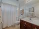 Bright bathroom featuring a wood vanity, framed mirror, and a shower/tub combo with a white curtain at 3174 Piney Woods Cir, Buford, GA 30519